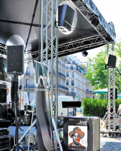 En médaillons : 2 clusters de 2 enceintes EAW JF100, 1 enceinte EAW sur pied, 1 renfort de graves EAW SB850 au sol