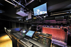 Salle 2 : régie fixe devant le dernier rang du balcon ; gain de place grâce au retour vidéo LCD et son projecteur, placés au-dessus de la régie